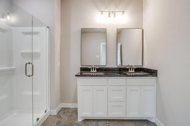 bathroom featuring a shower with shower door and vanity