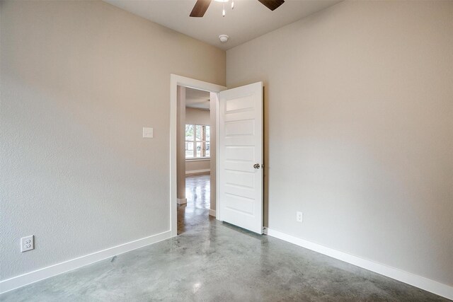 spare room featuring ceiling fan and concrete floors