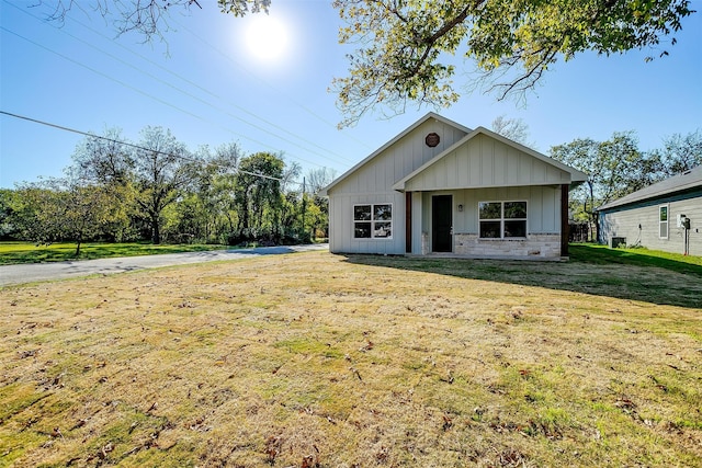 view of front of house with a front lawn and central air condition unit