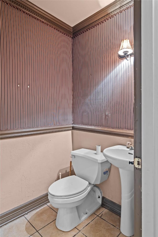 bathroom with tile patterned floors, toilet, and ornamental molding