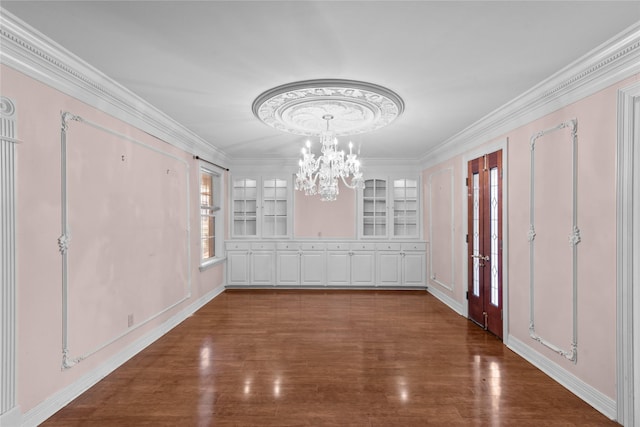 unfurnished dining area featuring crown molding, dark hardwood / wood-style floors, and an inviting chandelier