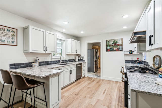 kitchen featuring white cabinetry, light hardwood / wood-style floors, appliances with stainless steel finishes, and sink