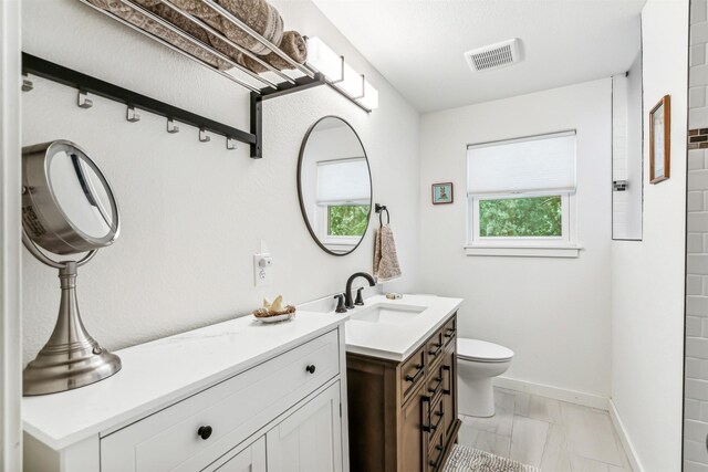 bathroom featuring vanity, tile patterned flooring, and toilet