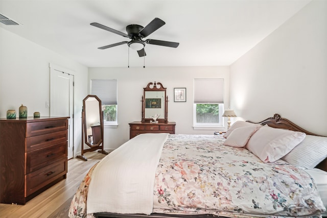 bedroom featuring light hardwood / wood-style flooring, multiple windows, and ceiling fan