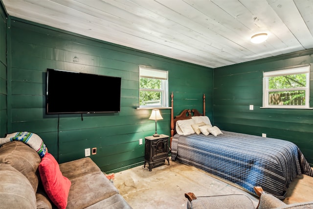 bedroom with a wood stove and wood ceiling