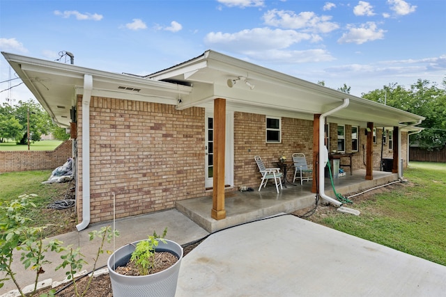 rear view of property featuring a patio and a lawn