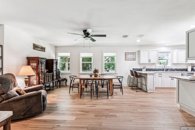 dining room featuring a healthy amount of sunlight, ceiling fan, and light wood-type flooring