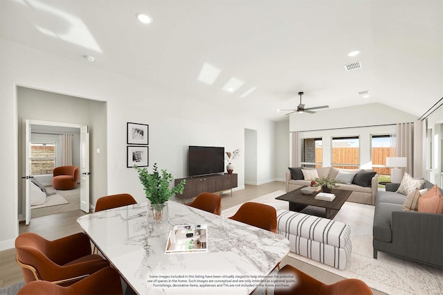 living room featuring ceiling fan, light hardwood / wood-style floors, and vaulted ceiling