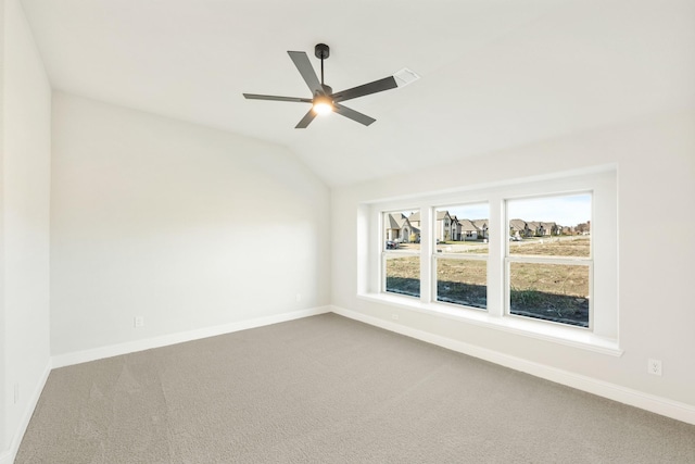 carpeted spare room featuring ceiling fan and vaulted ceiling