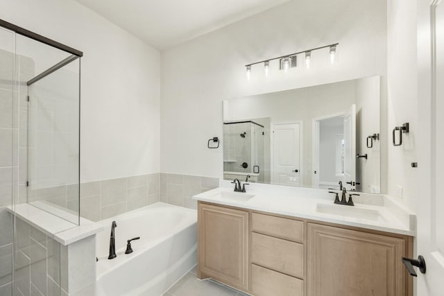 bathroom featuring tile patterned floors, vanity, and shower with separate bathtub