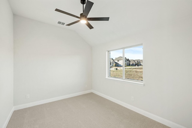 carpeted empty room with vaulted ceiling and ceiling fan