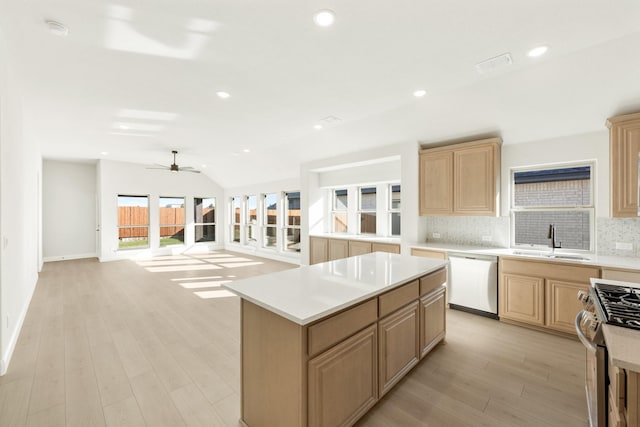 kitchen featuring a center island, sink, stainless steel appliances, and light brown cabinetry