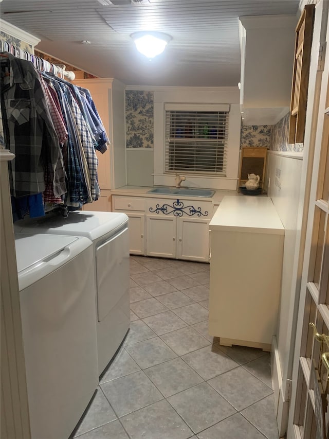 washroom with sink, washing machine and clothes dryer, cabinets, and light tile patterned floors