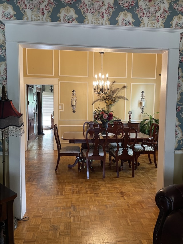 dining area with an inviting chandelier and parquet flooring