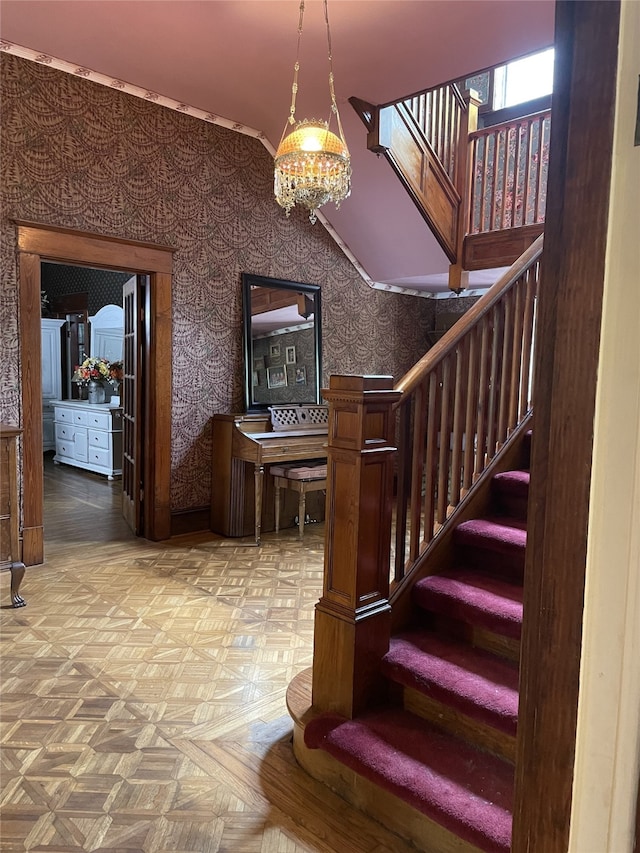 stairs featuring light parquet floors and a chandelier