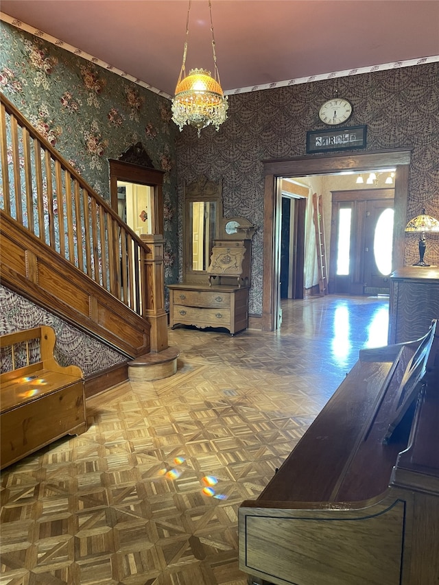 entrance foyer featuring a chandelier and parquet flooring