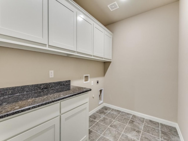 laundry room featuring light tile patterned flooring, cabinets, washer hookup, and hookup for an electric dryer