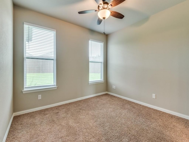 spare room with ceiling fan and light carpet