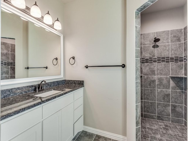 bathroom featuring a tile shower, vanity, and tile patterned floors