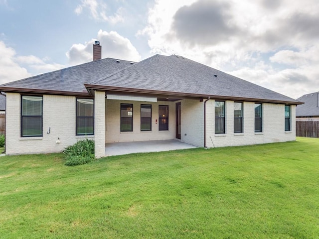 back of property featuring a patio area and a lawn