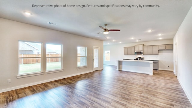 unfurnished living room with ceiling fan and light wood-type flooring