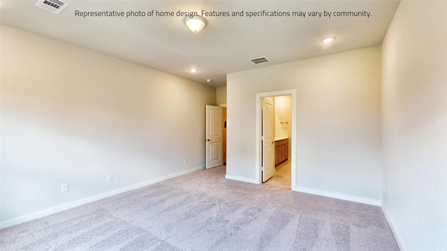 unfurnished bedroom featuring ensuite bathroom and light colored carpet