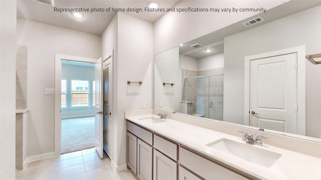 bathroom with a shower with door, vanity, and tile patterned flooring