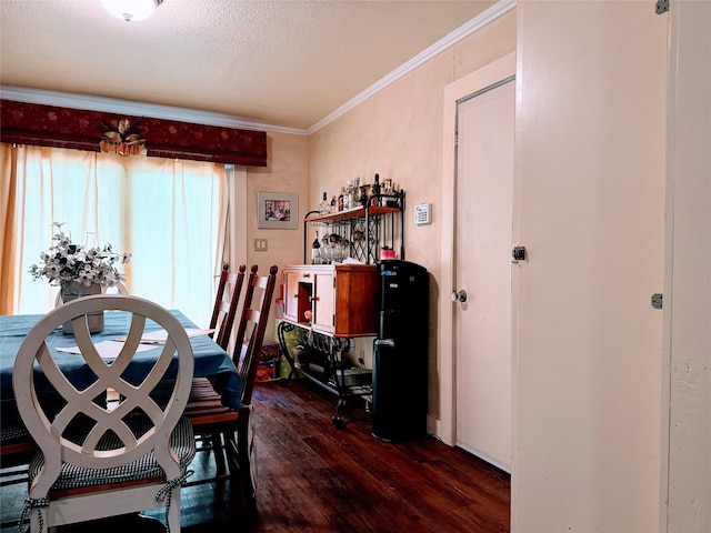 dining space featuring dark hardwood / wood-style flooring, ornamental molding, and a textured ceiling