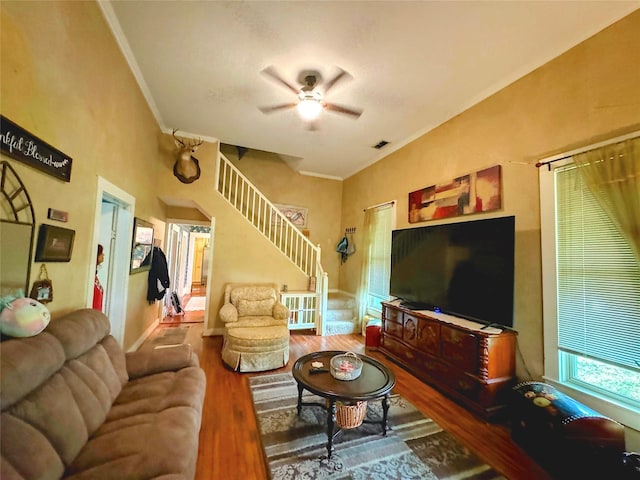 living room with hardwood / wood-style floors, crown molding, and ceiling fan