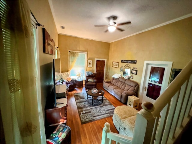 living room with hardwood / wood-style flooring, ornamental molding, and ceiling fan