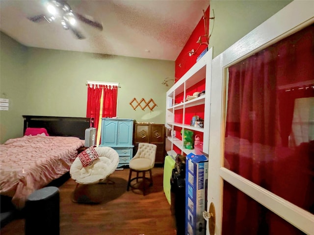 bedroom featuring ceiling fan, hardwood / wood-style floors, and a textured ceiling