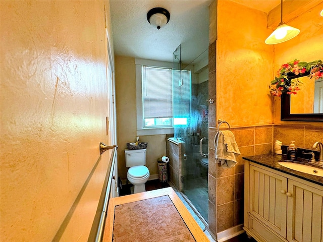 bathroom with vanity, tile walls, an enclosed shower, and toilet