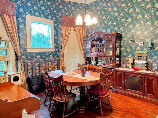 dining area featuring wood-type flooring, a healthy amount of sunlight, and a notable chandelier