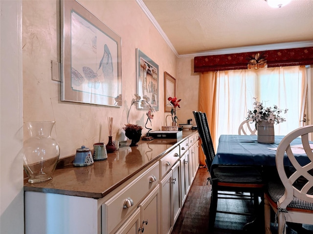 kitchen featuring crown molding, dark hardwood / wood-style flooring, and a textured ceiling