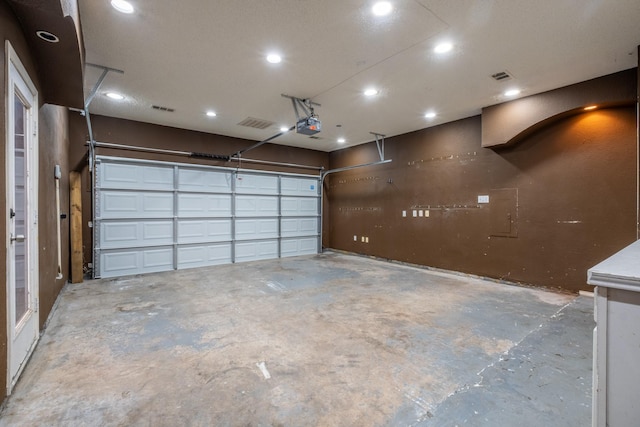 garage with a garage door opener and visible vents