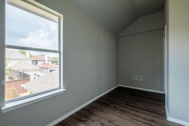 additional living space featuring lofted ceiling, visible vents, dark wood finished floors, and baseboards