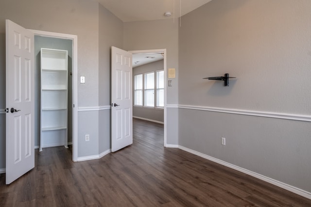 unfurnished bedroom with dark wood-type flooring