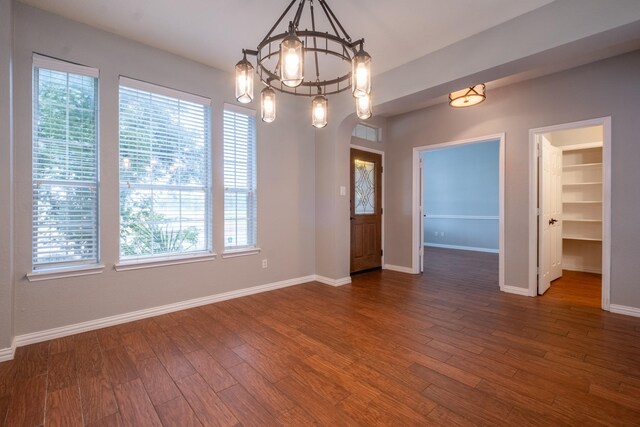 unfurnished dining area featuring hardwood / wood-style flooring and a chandelier