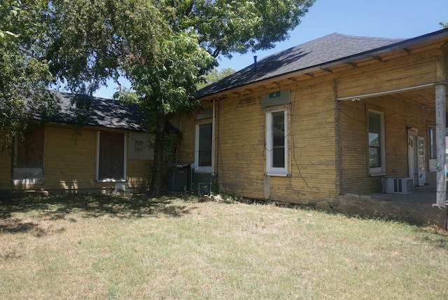 view of home's exterior with central air condition unit and a lawn