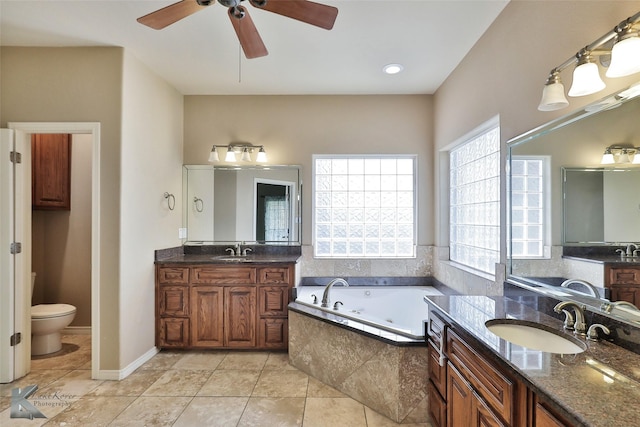 bathroom featuring toilet, vanity, ceiling fan, tile patterned floors, and tiled tub