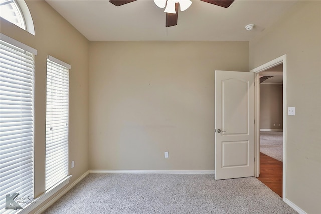 spare room with ceiling fan and light colored carpet