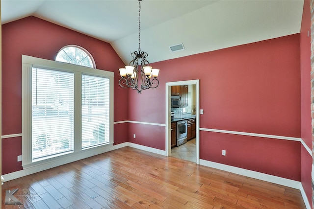 unfurnished dining area with light wood-type flooring, lofted ceiling, and a notable chandelier