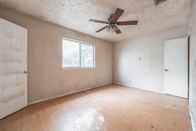 unfurnished room with ceiling fan, light hardwood / wood-style floors, and a textured ceiling