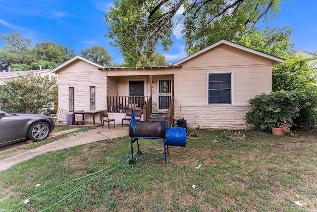 view of front of house featuring covered porch and a front yard