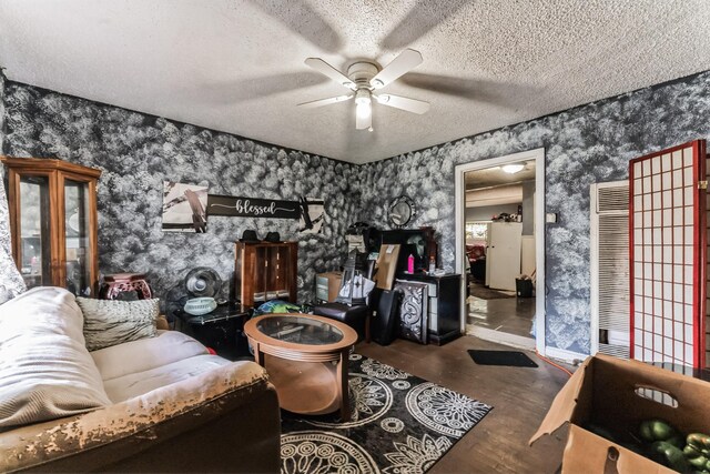 living room featuring hardwood / wood-style flooring, a textured ceiling, and ceiling fan