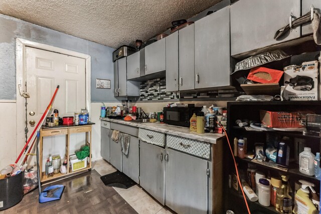 kitchen with gray cabinets, light parquet flooring, and a textured ceiling