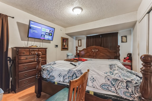 bedroom with wood-type flooring, a closet, and a textured ceiling