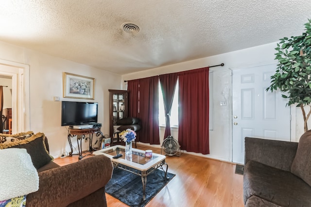 living room with light hardwood / wood-style flooring and a textured ceiling