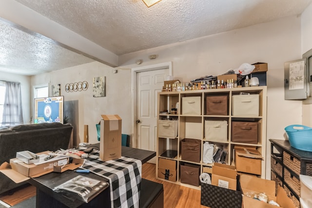 interior space with a textured ceiling and hardwood / wood-style floors