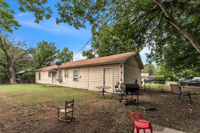 rear view of house featuring a lawn and cooling unit